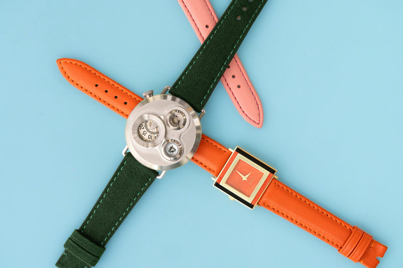 Farbige Uhrenarmbänder auf hellblauem Hintergrund