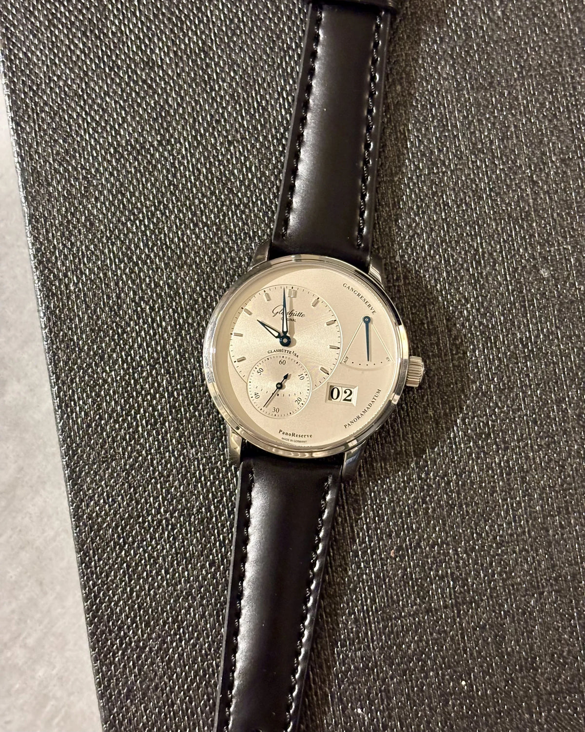 Glashütte Original PanoReserve mit schwarzem Cordovan „9 to 5“ – Gesamtansicht auf Stoff