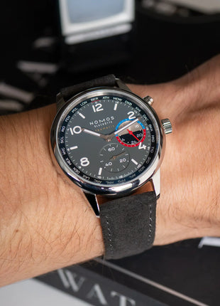 Alcantara® 9 to 5 an NOMOS Club Sport neomatik Weltzeit Volcano – Lifestyleaufnahme am Handgelenk